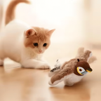 Cat playing with a toy penguin on a soft surface